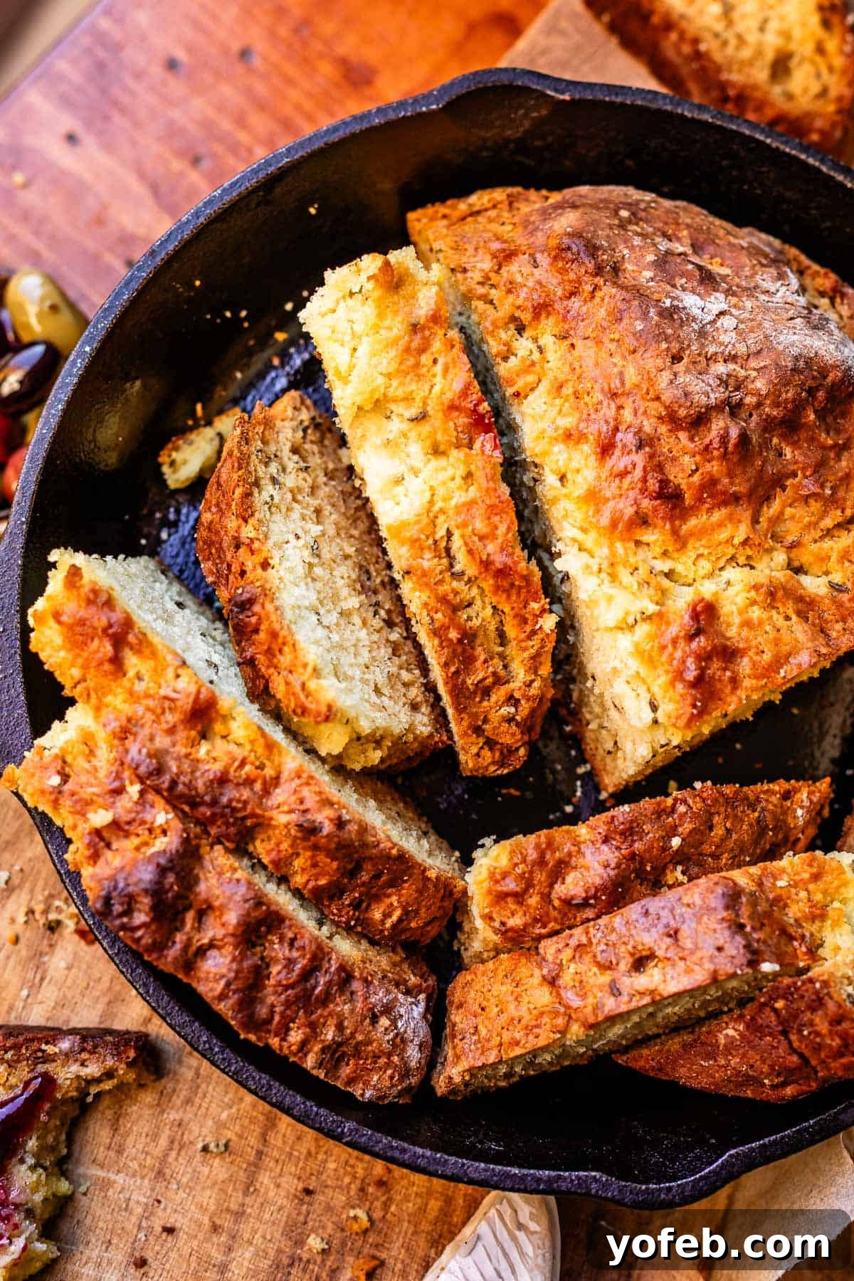 Pure Irish Soda Bread Perfection 18 Overhead shot of loaf of Irish soda bread cut into many different slices sitting in cast iron skillet.