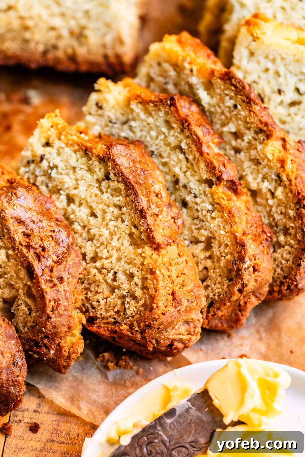 Pure Irish Soda Bread Perfection 19 Slices of Irish soda bread nested over each other with butter in the foreground.