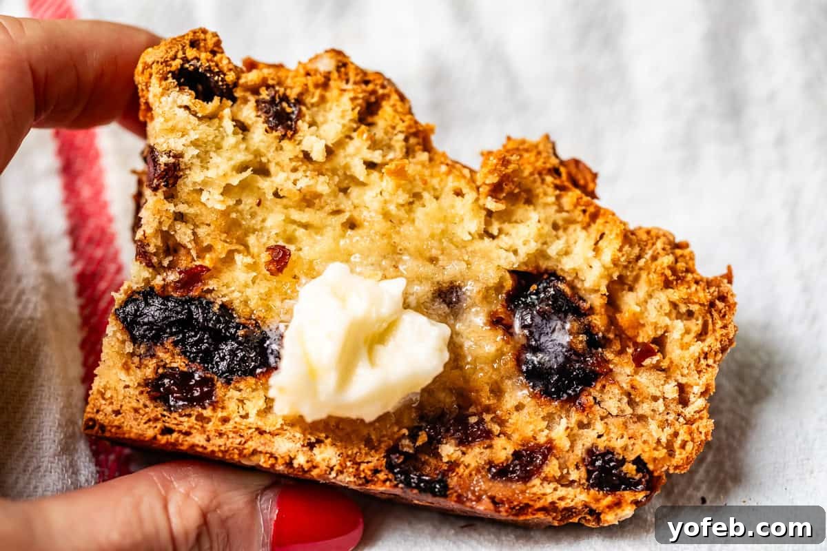 Pure Irish Soda Bread Perfection 20 Close-up of soda bread showing baked-in cherries and raisin with pat of butter melting on the center.