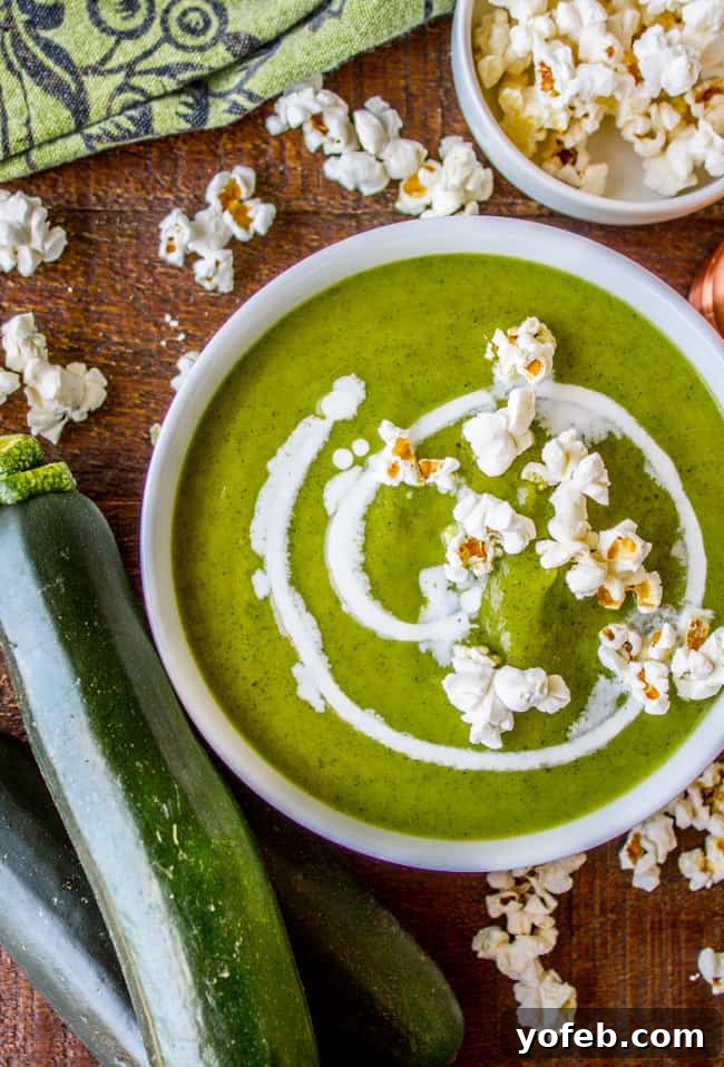 A bowl of zucchini soup topped with popcorn.