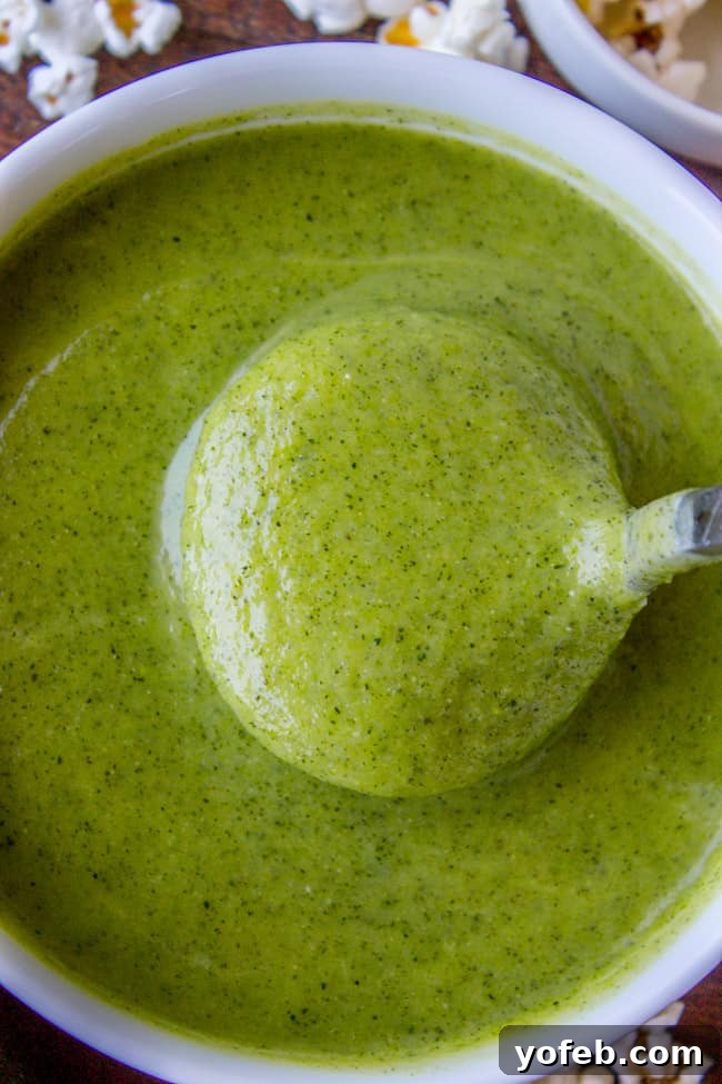 Zucchini Velvet with a Pop of Corn 9 A spoonful of creamy zucchini soup, highlighting its smooth and luxurious texture.
