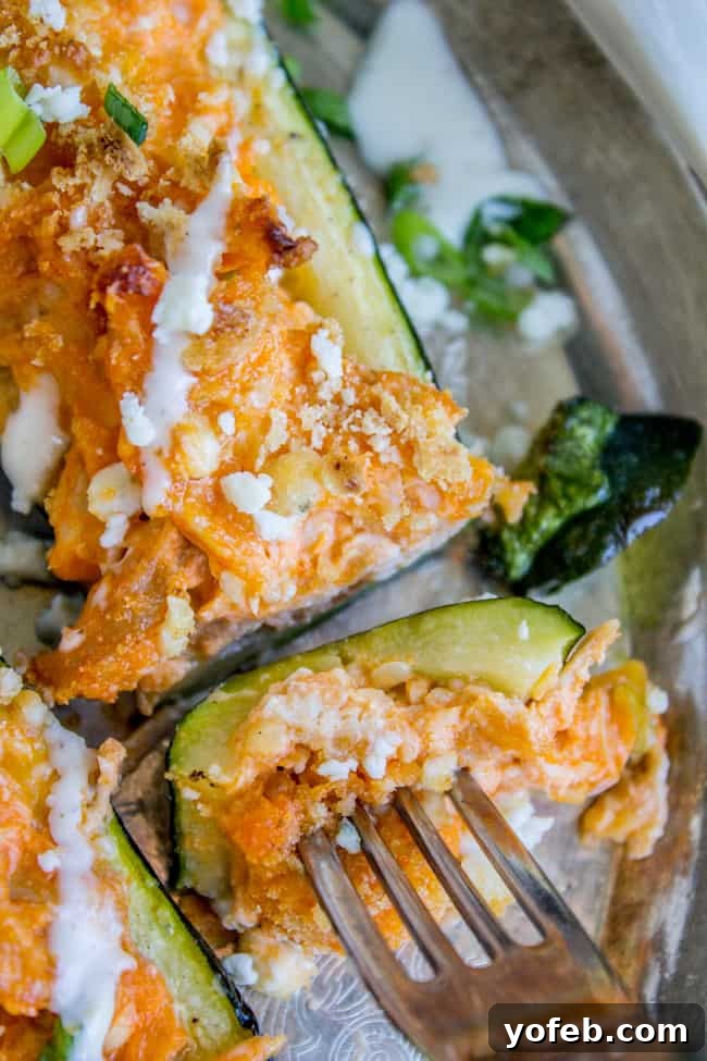 Fiery Buffalo Chicken Zucchini Boats 4 A fork and a bite of buffalo chicken zucchini boats, ready to eat.