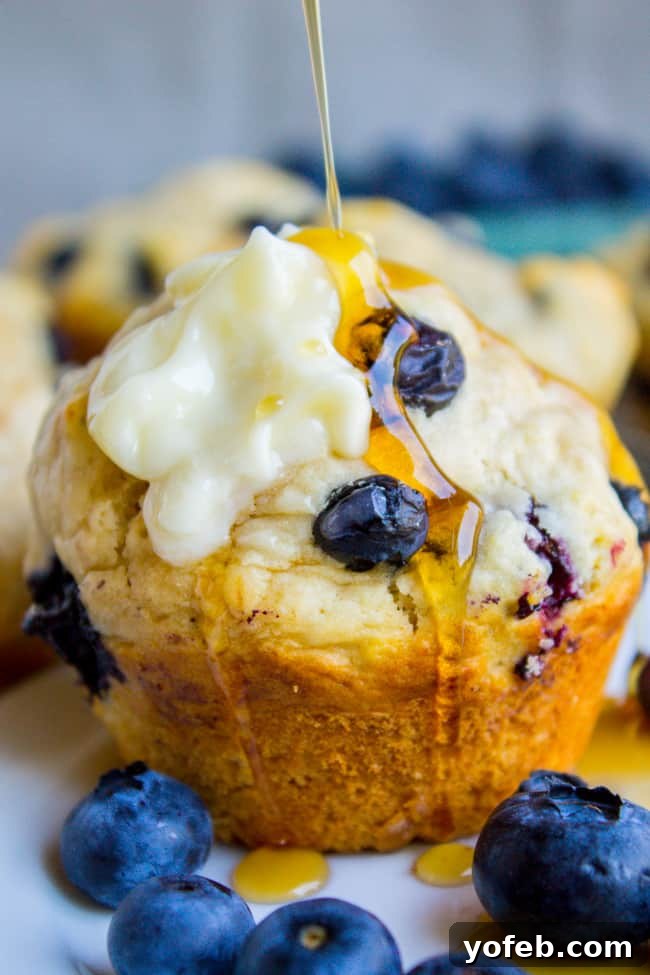 Homemade Pancake Muffins 4 Warm Blueberry Buttermilk Pancake Muffins being drizzled with sweet maple syrup, an irresistible breakfast treat.