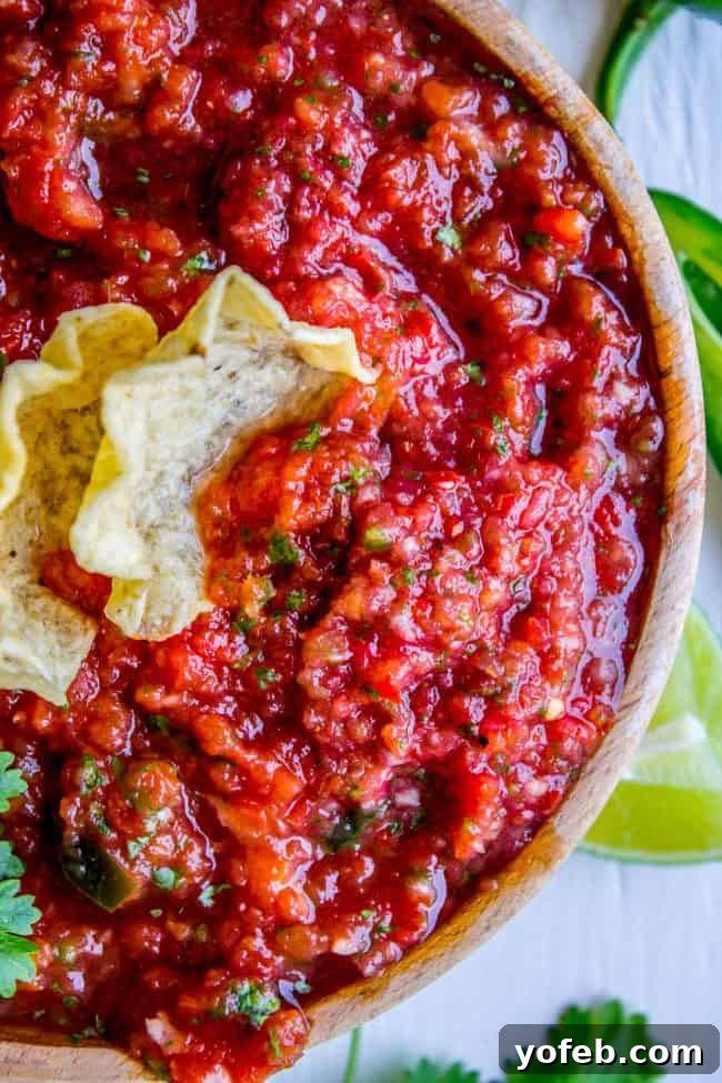 Salsa in 5: Restaurant Flavor for Your Best Taco Tuesday Yet 3 fresh homemade salsa in a brown bowl with tortilla chips in it scooping up salsa.