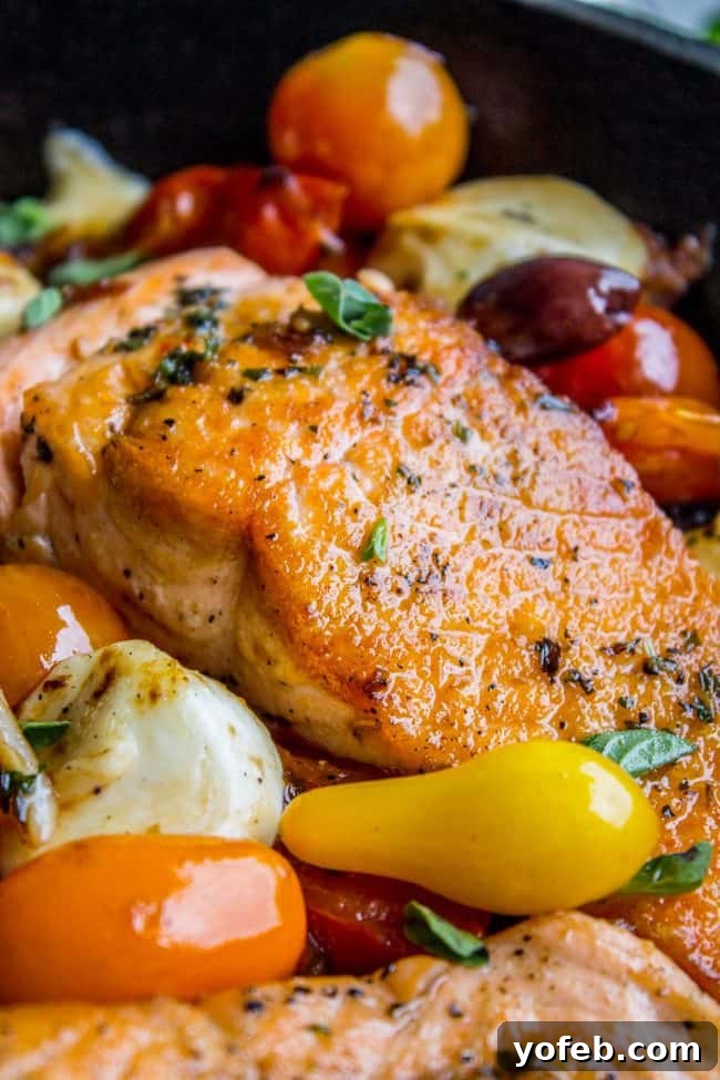 Speedy Pan-Seared Salmon with Burst Tomatoes and Melted Mozzarella 9 Close-up of a beautifully crusted pan-seared salmon fillet surrounded by vibrant cherry tomatoes and herbs.