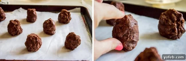 Decadent Double Chocolate Chip Cookies 11 Hands carefully shaping dark chocolate cookie dough into tall, egg-like forms on a parchment-lined baking pan.