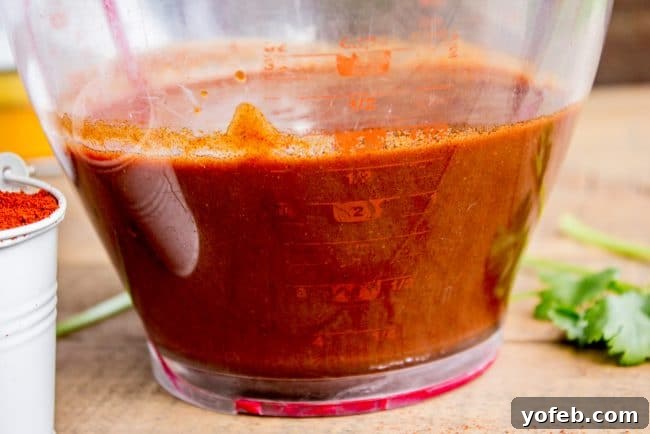 Speedy Homemade Enchilada Sauce 8 A plastic measuring cup filled with perfectly prepared, thick red enchilada sauce, demonstrating the ideal amount for a baking pan.