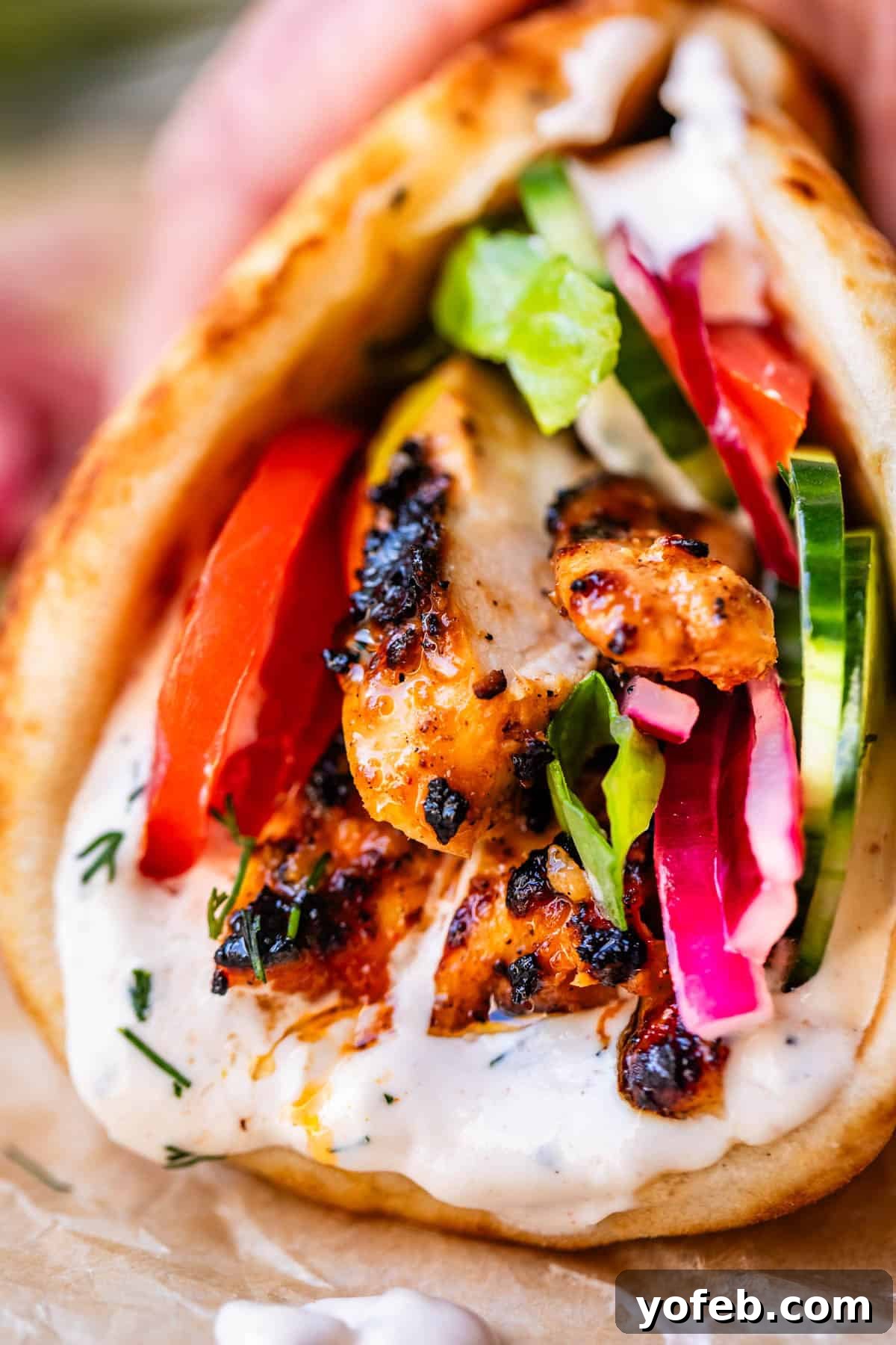 Tender Lebanese Beef and Green Bean Braise 13 close up of chicken shawarma in naan with cucumber, onion, and garlic sauce.