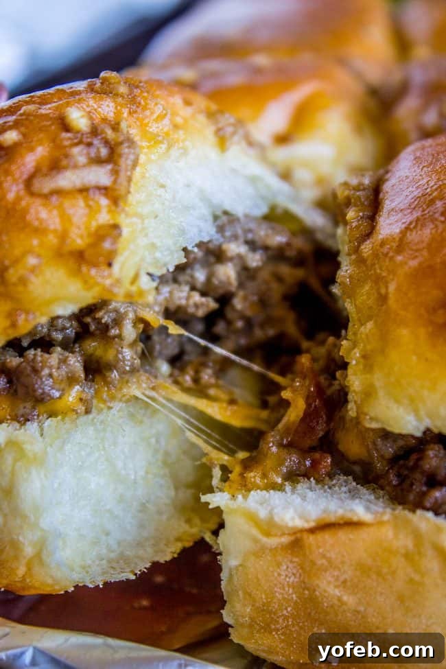 Irresistible Mini Burgers 2 Cheeseburger sliders pulled apart, showing gooey cheese and tender beef on Hawaiian rolls.