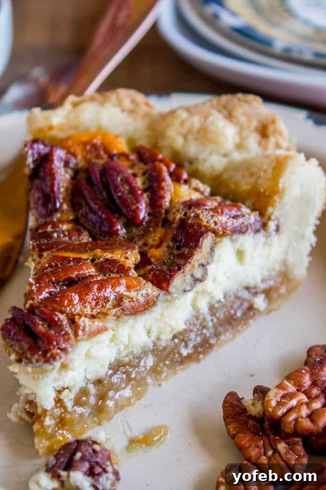Decadent Pecan Cheesecake Pie 2 A stunning Cheesecake Pecan Pie slice, showcasing layers of flaky crust, creamy cheesecake, and rich pecan topping, drizzled with caramel sauce and topped with whipped cream.