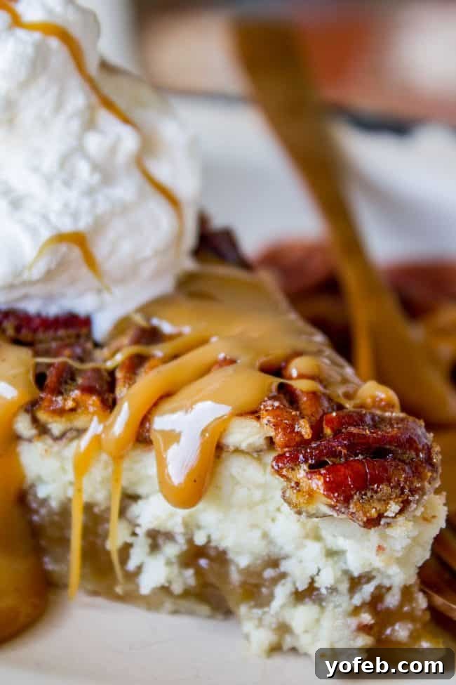 Decadent Pecan Cheesecake Pie 4 Close-up of a generous slice of Cheesecake Pecan Pie, garnished with caramel sauce and a dollop of fresh whipped cream, ready to be enjoyed.