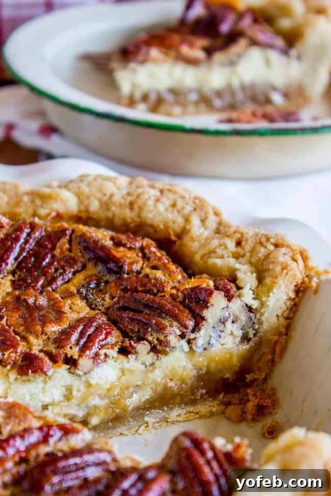 Decadent Pecan Cheesecake Pie 7 A baked Cheesecake Pecan Pie sitting in a pie dish, showcasing its golden crust and rich, glossy pecan topping, ready for chilling and serving.