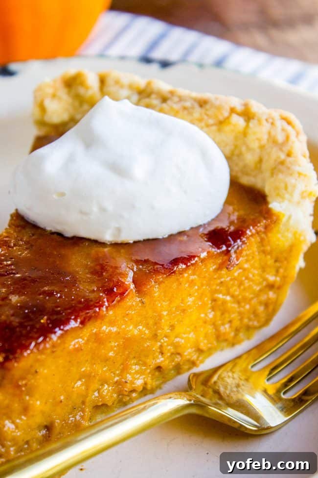 A Decadent Pumpkin Pie with Crème Brulée 5 a slice of pumpkin pie with crackly creme brulee topping and fresh whipped cream.