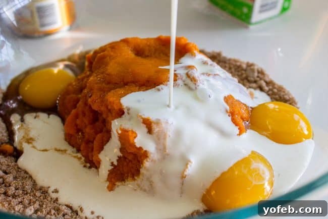A Decadent Pumpkin Pie with Crème Brulée 9 pouring cream into a bowl with pumpkin, eggs, and other ingredients for pumpkin pie filling.
