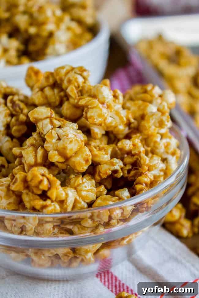 Effortless 10-Minute Microwave Caramel Corn 2 Golden caramel corn served in a clear glass bowl, showing its shiny coating and readiness to be eaten.
