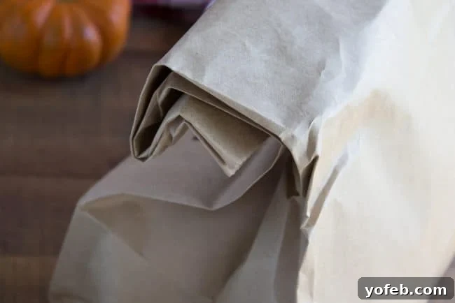 Brown Paper Bag Prep for Caramel Popcorn A large, clean brown paper grocery bag, positioned open and ready to receive the popcorn and caramel mixture.