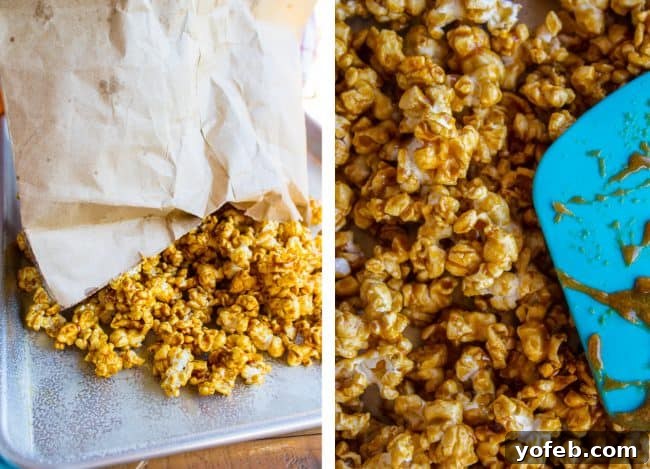 Spreading Coated Popcorn to Cool Freshly mixed caramel popcorn being poured and spread out on a prepared baking sheet to cool and crisp up.