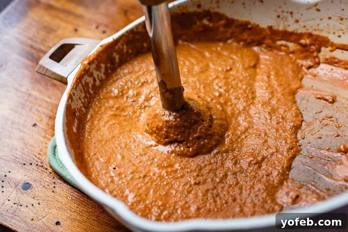 Chicken Tikka Masala A Culinary Revelation 14 immersion blender in pan with now blended and smooth sauce.