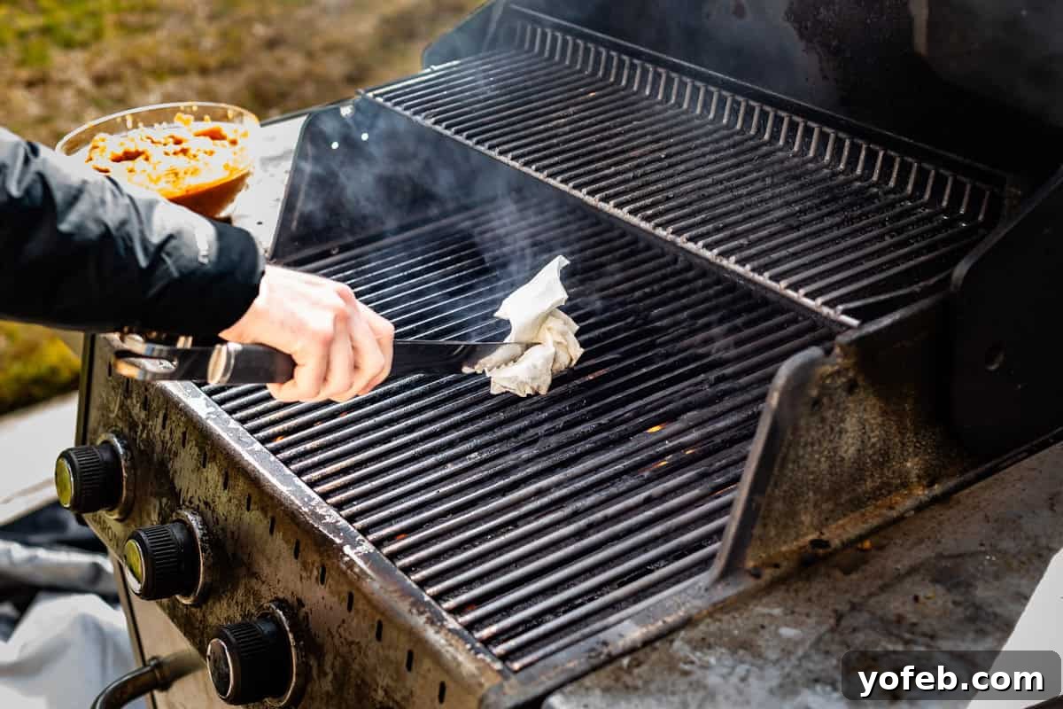 Chicken Tikka Masala A Culinary Revelation 15 oiling grates of outdoor grill using a paper towel and tongs.