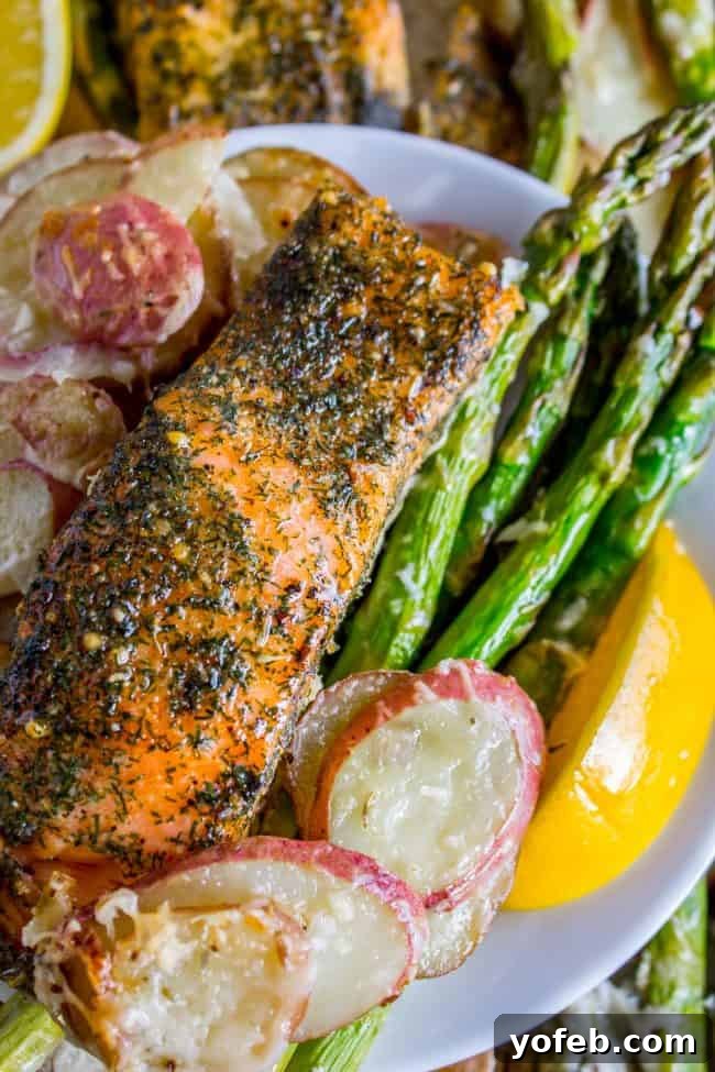 Sheet Pan Salmon with Creamy Scalloped Potatoes and Asparagus from The Food Charlatan. Don't you just love sheet pan dinners?? They are so easy and there's only ONE DISH to wash! This Citrus Herb Salmon is paired with creamy scalloped potatoes and fresh asparagus to make a super easy, pretty healthy, and DELICIOUS one pan meal. #dinner #asparagus #sheetpan #onepan #salmon #lemon #healthy #roastedsalmon #easy #quick #herb #potatoes #creamy #recipe #mealprep #weeknight #salmonrecipesbaked #salmondinner #onesheetpanmeals #sheetpanmeals Sheet pan salmon and potatoes