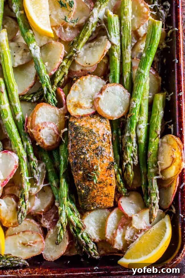 Sheet Pan Salmon with Creamy Scalloped Potatoes and Asparagus from The Food Charlatan. Don't you just love sheet pan dinners?? They are so easy and there's only ONE DISH to wash! This Citrus Herb Salmon is paired with creamy scalloped potatoes and fresh asparagus to make a super easy, pretty healthy, and DELICIOUS one pan meal. #dinner #asparagus #sheetpan #onepan #salmon #lemon #healthy #roastedsalmon #easy #quick #herb #potatoes #creamy #recipe #mealprep #weeknight #salmonrecipesbaked #salmondinner #onesheetpanmeals #sheetpanmeals Salmon asparagus and potatoes