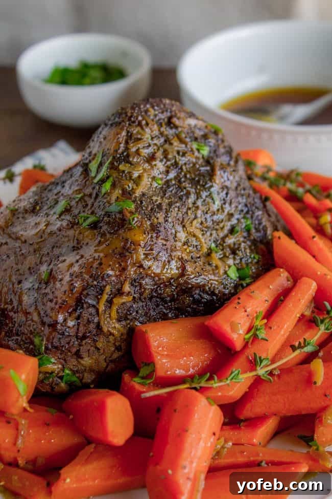Easy Fall-Apart Pot Roast with Carrots (Slow Cooker) from The Food Charlatan. Super tender, juicy, fall-apart crock pot roast is not as hard as you think! This slow cooker recipe uses a few simple ingredients (one of them is patience) to make the most flavorful pot roast ever! #potroast #slowcooker #crockpot #roast #chuckroast #tender #juicy Pot roast with carrots. A succulent pot roast, cooked to fork-tender perfection, presented alongside vibrant, perfectly cooked carrots. The rich, savory aroma promises a truly satisfying meal.