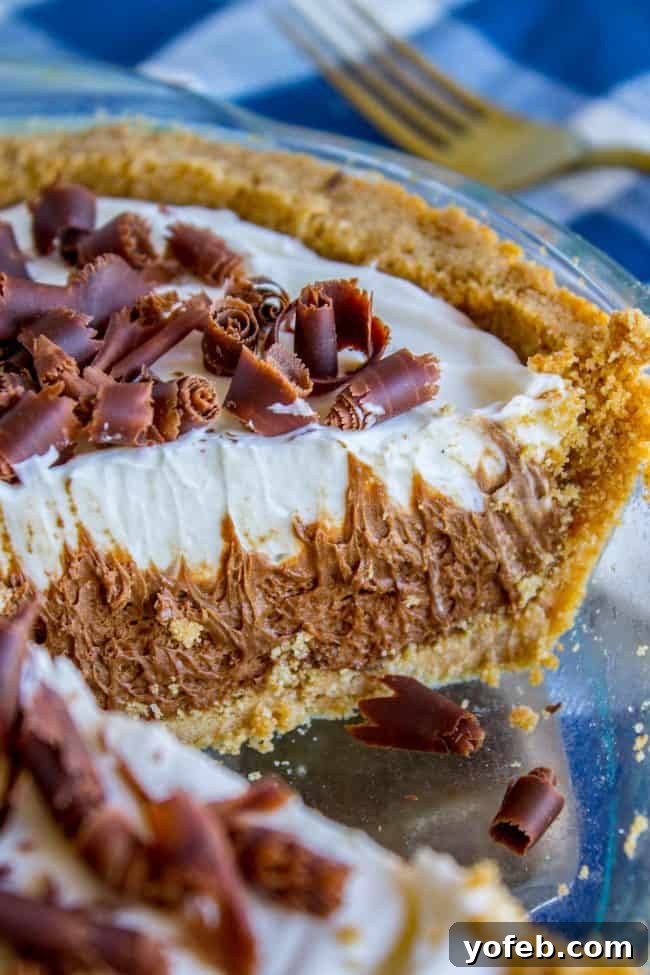 Side shot of French Silk Pie A beautiful side profile of French Silk Pie, highlighting the harmonious layers of the golden graham cracker crust, dark chocolate filling, and fluffy white whipped cream.
