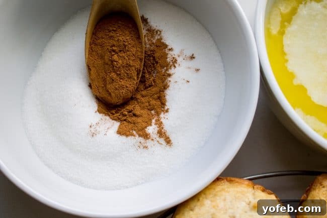 Sugared Cinnamon Morning Muffins 9 A warm, golden-brown muffin being dipped into a bowl of melted butter, a crucial step for achieving the signature crust of French Breakfast Puffs.