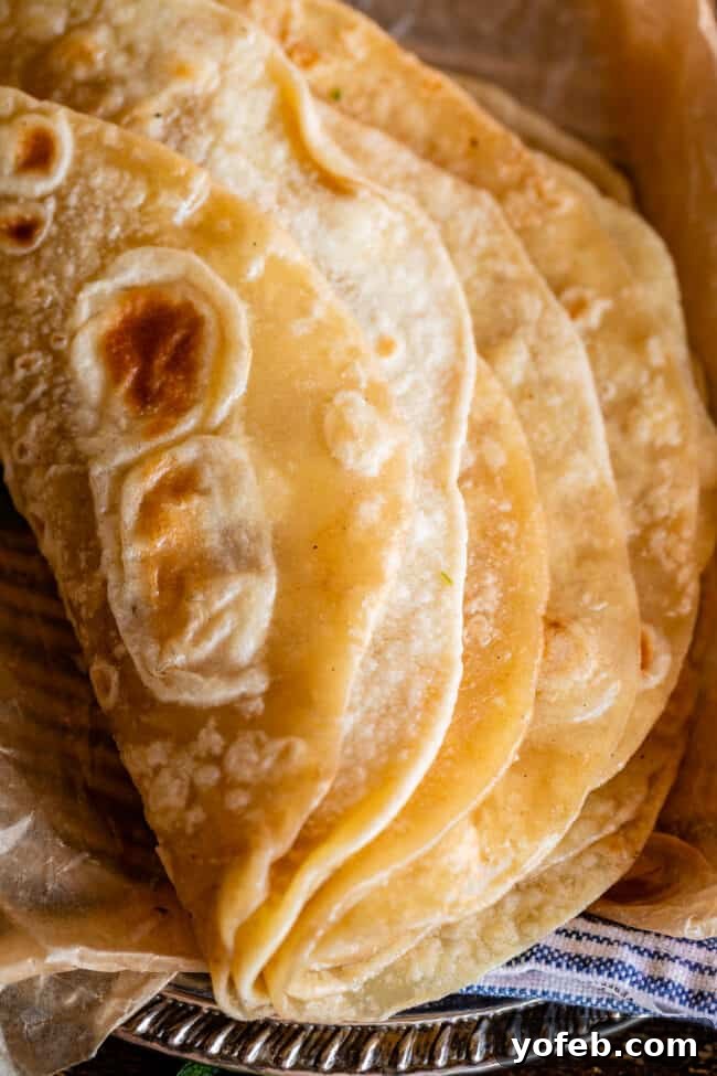 Roti Buttery Indian Flatbread Perfection 6 Indian bread stacked and folded over on a metal plate with blue napkin.