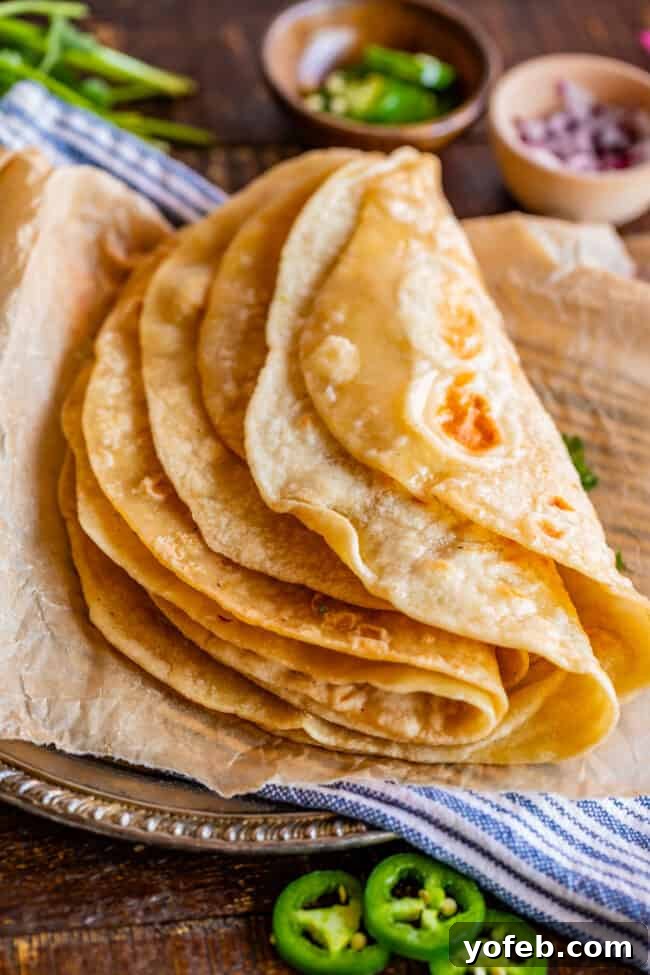 Roti Buttery Indian Flatbread Perfection 10 Indian roti bread on a metal plate with blue napkin and parchment paper.