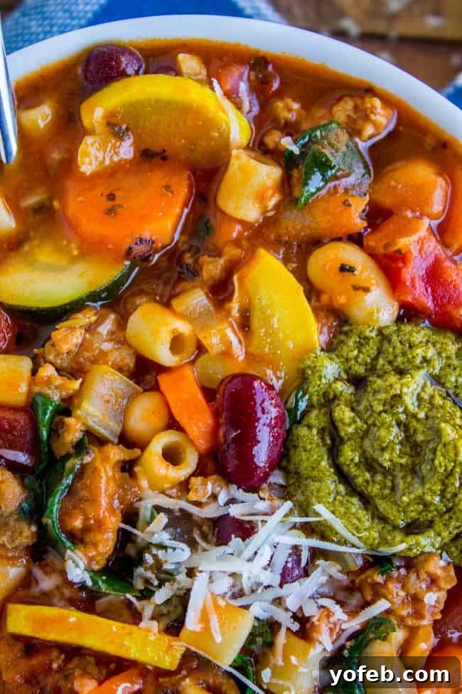 Minestrone Soup Bowl with Fresh Pesto Garnish minestrone soup in a bowl with pesto.