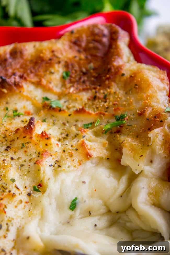 Crispy Make-Ahead Italian Mashed Potatoes for Festive Feasts Mashed potatoes with a golden brown crispy topping in a casserole dish, ready to serve.
