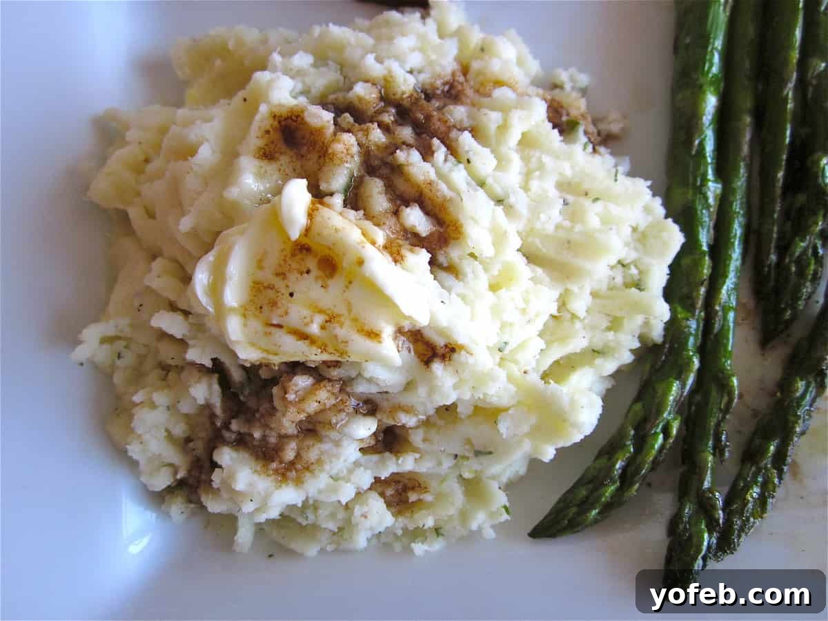 Creamy Mashed Potatoes with Herbs A beautifully presented bowl of creamy mashed potatoes, garnished with fresh herbs and a pat of melted butter, ready to be served as a delightful side dish.