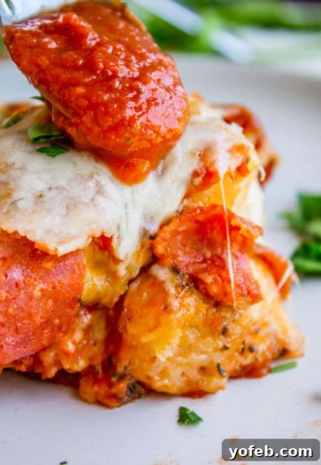 Quick & Easy Biscuit Pizza Casserole Prepared Easy Pizza Casserole layered with biscuit pieces, pepperoni, and mozzarella before baking.