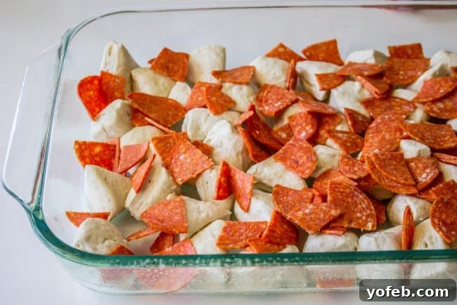 Cheesy Easy Pizza Casserole A close-up of a serving of Easy Pizza Casserole with melted mozzarella and visible biscuit pieces.