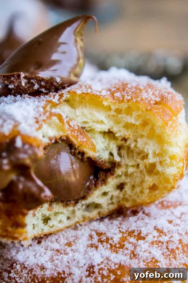 Step-by-step guidance on how to make stuffed donuts, ensuring soft, puffy, and perfectly fried results every time, ready for your favorite filling. Detailed view of the process of making stuffed donuts, from dough preparation to shaping, highlighting the care taken in creating these delectable treats.