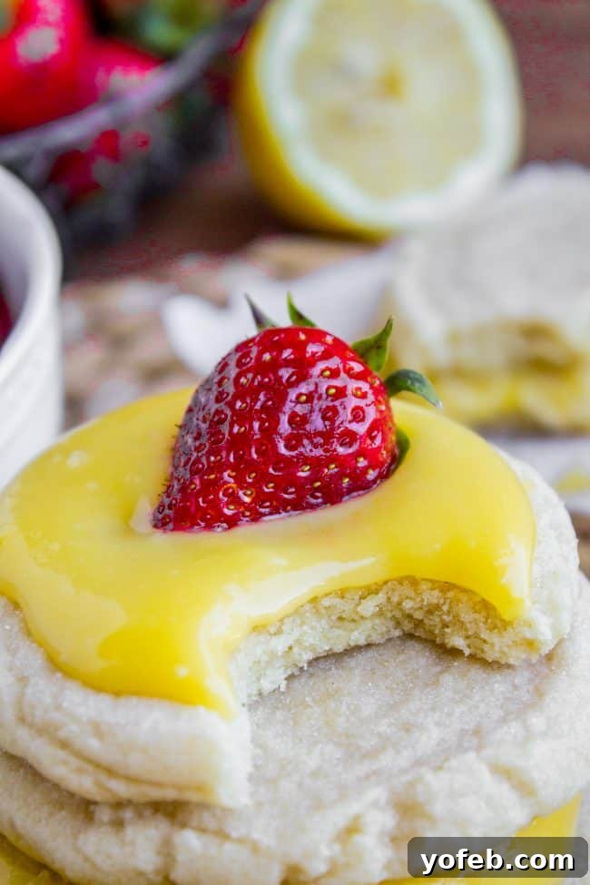 Lemon Curd and Strawberry Sugar Cookie Sandwiches - A Delightful Combination Several lemon curd sugar cookie sandwiches on a serving plate, adorned with fresh strawberry slices, emphasizing their fresh and fruity appeal.