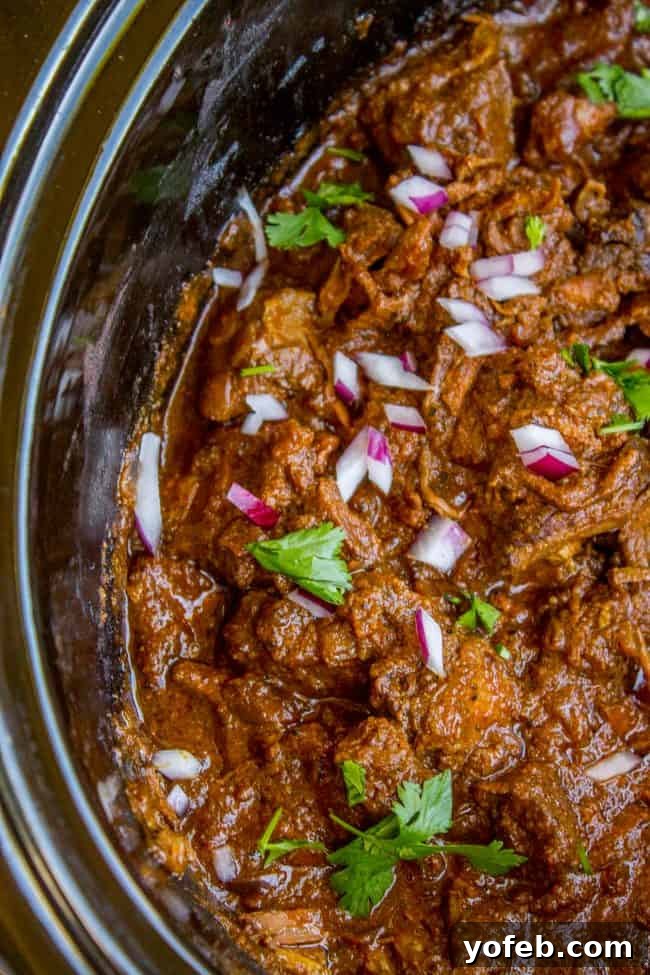 Slow Cooker Beef Curry: Effortless, flavorful, and incredibly tender. A perfect weeknight meal. Close-up of slow cooker beef curry garnished with fresh cilantro and red onion, highlighting the rich, thick sauce and tender beef chunks. An incredibly simple and flavorful dish for any day.