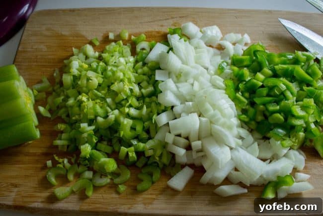 Soulful Cajun Red Beans and Rice 6 Freshly chopped onion and celery, neatly arranged on a rustic wooden cutting board, ready for cooking.