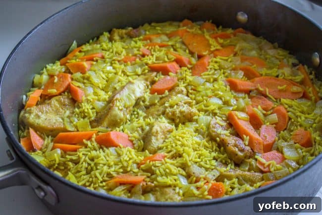Aromatic Indian Chicken Biryani 11 Chicken Biryani simmering under a lid in a large skillet on the stovetop.