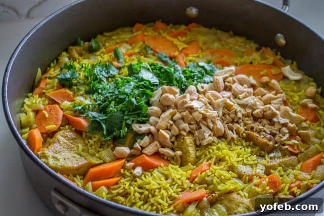 Aromatic Indian Chicken Biryani 12 Adding fresh cilantro and cashews to the finished Stovetop Chicken Biryani, ready to be mixed.