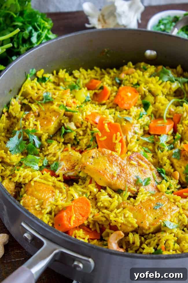Aromatic Indian Chicken Biryani 7 Close-up of Chicken Biryani simmering in a skillet on the stovetop, showcasing the vibrant colors of chicken, rice, and carrots.