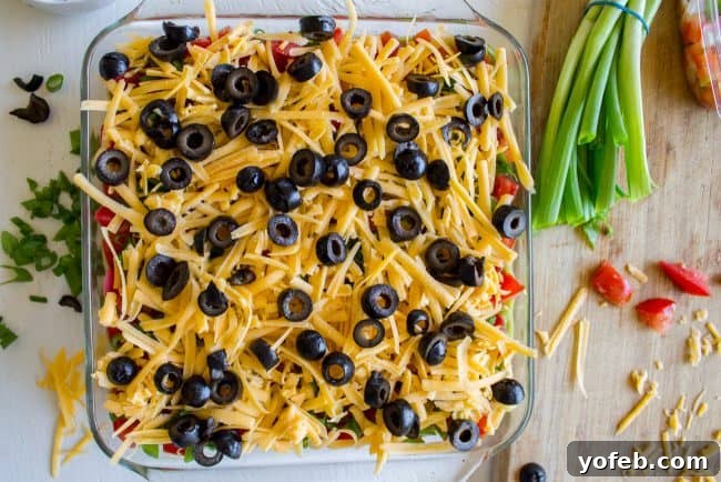 Carols Epic Seven Layer Bean Dip 11 shredded cheese and black olives on top of dip.