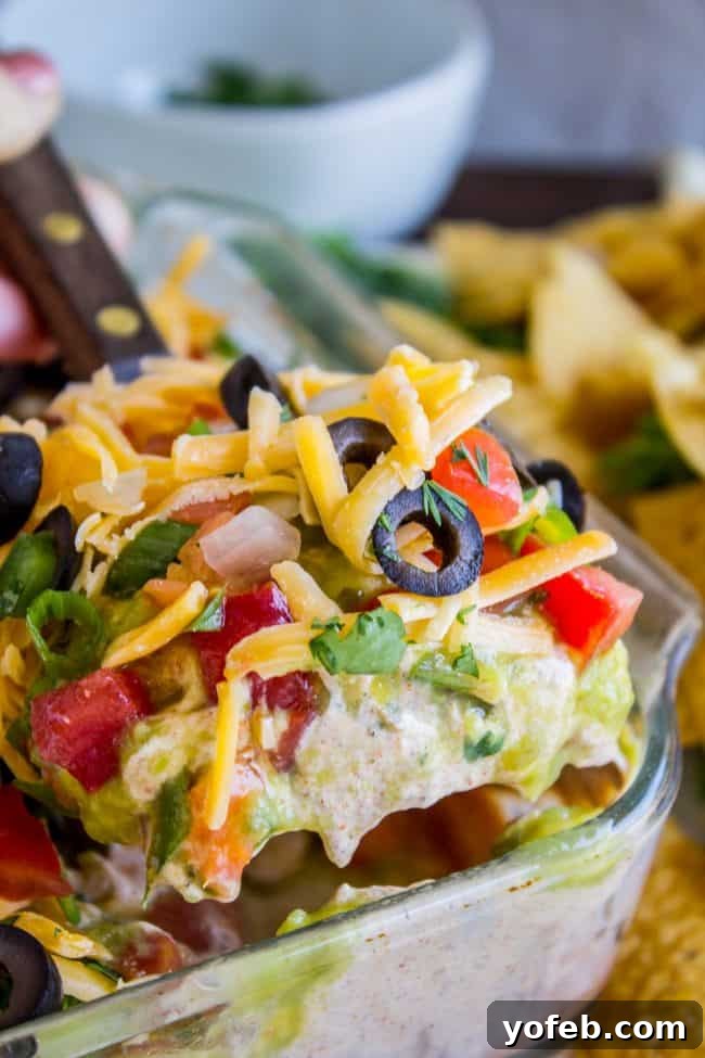 Carols Epic Seven Layer Bean Dip 5 Scooping up 7 layer bean dip.