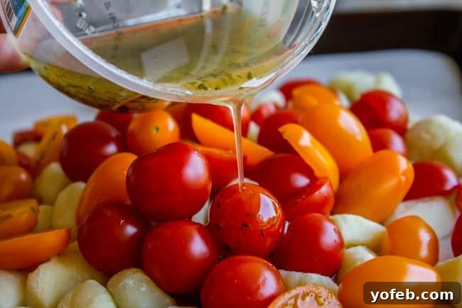 Golden-brown roasted gnocchi and tender cherry tomatoes mingle with fresh mozzarella pearls, creating a colorful and inviting dish.