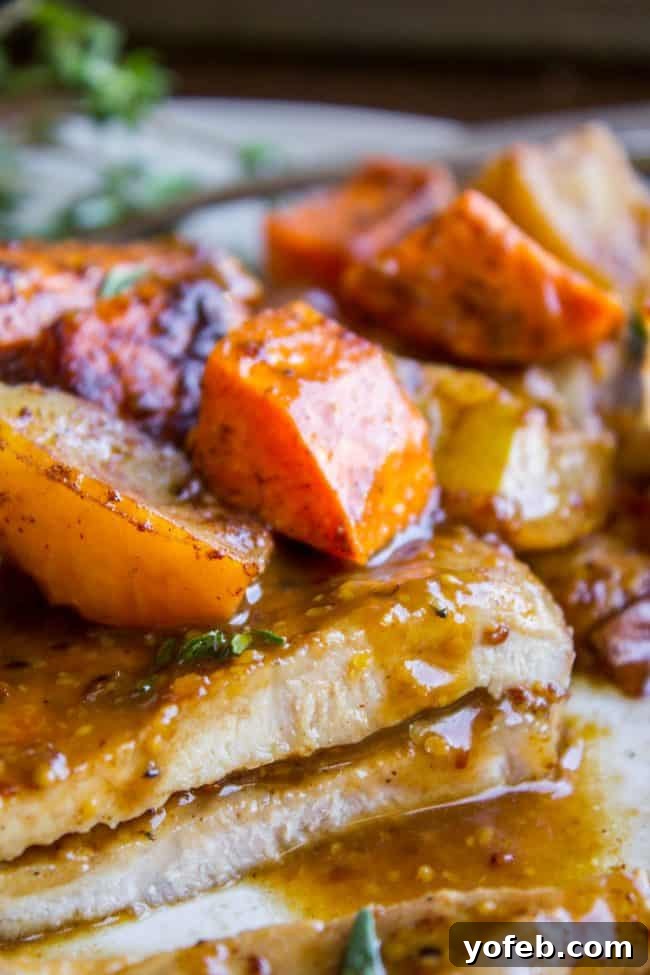 Glazed Pork Chops with Apples from The Food Charlatan. These Pork Chops with Apples are such an easy weeknight dinner! They are done in just a few minutes, and finished off in a delicious apple cider glaze. The cinnamon-spiced roasted apples and sweet potatoes will have your house smelling like autumn in no time. #apple #roasted #fall #cinnamon #applecider #onion #dinner #easy #weeknight #easy #fried #recipe #boneless #sauce #healthy #glazed Juicy pork chops with roasted sweet potatoes, apples, and onions in a warm, inviting light.