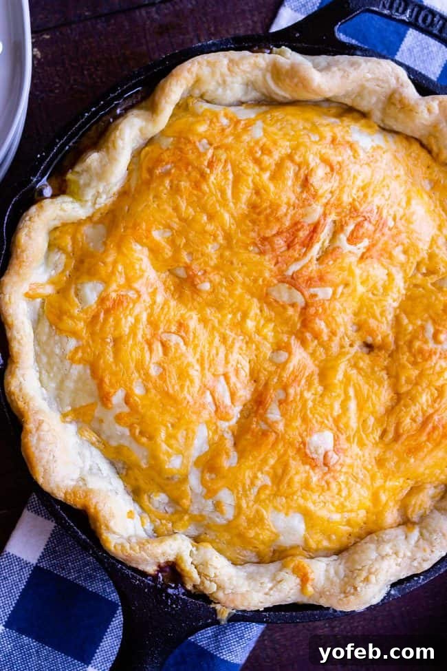 One Skillet Shepherd's Pot Pie from The Food Charlatan. It's like Shepherd's Pie and Chicken Pot Pie got together and had a baby to make a One Skillet Shepherd's Pot Pie! Regular skillet shepherd's pie would feature mashed potatoes, but instead we are covering ours up with a super flaky pie crust, just like it's a pot pie. It's comfort food heaven!! #recipe #easy #best #beef #traditional #skillet #castiron #casserole #withgravy #withcrust #cheddar #onepot #cheese #carrots #peas #flaky #crust skillet shepherds pot pie with flaky crust