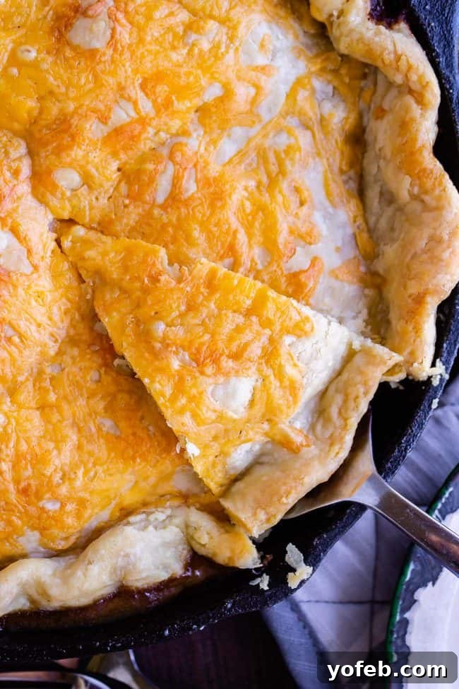 One Skillet Shepherd's Pot Pie from The Food Charlatan. It's like Shepherd's Pie and Chicken Pot Pie got together and had a baby to make a One Skillet Shepherd's Pot Pie! Regular skillet shepherd's pie would feature mashed potatoes, but instead we are covering ours up with a super flaky pie crust, just like it's a pot pie. It's comfort food heaven!! #recipe #easy #best #beef #traditional #skillet #castiron #casserole #withgravy #withcrust #cheddar #onepot #cheese #carrots #peas #flaky #crust shepherds pot pie with flaky crust