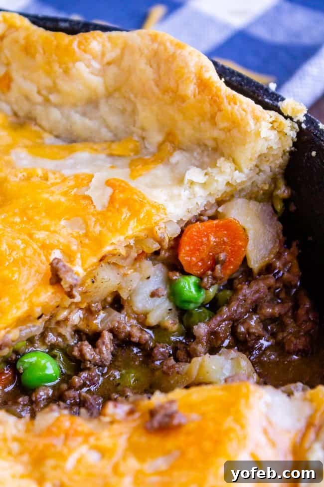 One Skillet Shepherd's Pot Pie from The Food Charlatan. It's like Shepherd's Pie and Chicken Pot Pie got together and had a baby to make a One Skillet Shepherd's Pot Pie! Regular skillet shepherd's pie would feature mashed potatoes, but instead we are covering ours up with a super flaky pie crust, just like it's a pot pie. It's comfort food heaven!! #recipe #easy #best #beef #traditional #skillet #castiron #casserole #withgravy #withcrust #cheddar #onepot #cheese #carrots #peas #flaky #crust skillet shepherds pie with golden flaky crust