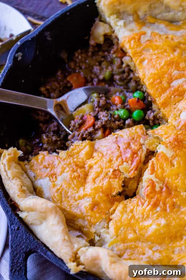 One Skillet Shepherd's Pot Pie from The Food Charlatan. It's like Shepherd's Pie and Chicken Pot Pie got together and had a baby to make a One Skillet Shepherd's Pot Pie! Regular skillet shepherd's pie would feature mashed potatoes, but instead we are covering ours up with a super flaky pie crust, just like it's a pot pie. It's comfort food heaven!! #recipe #easy #best #beef #traditional #skillet #castiron #casserole #withgravy #withcrust #cheddar #onepot #cheese #carrots #peas #flaky #crust shepherd's pot pie with flaky crust